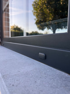 Anthracite aluminium window frame on a bluestone sill after coating, tape removed, clean edge